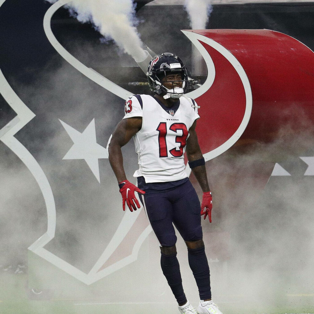 Brandin Cooks in full Houston Texans uniform with bold Texans logo and smoky NFL background Wallpaper