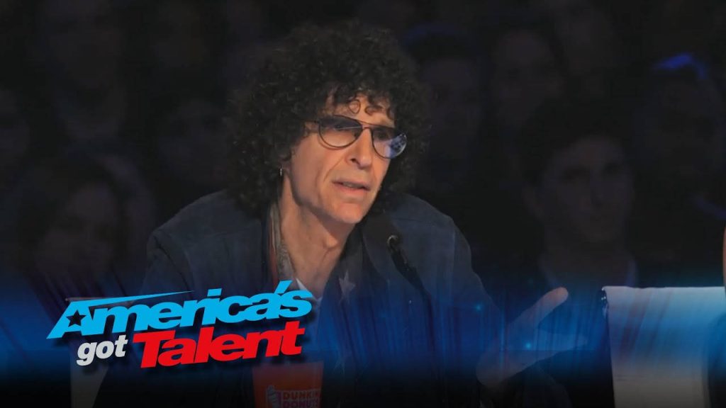 Howard Stern critique moment on Americas Got Talent set with vibrant AGT logo background wallpaper