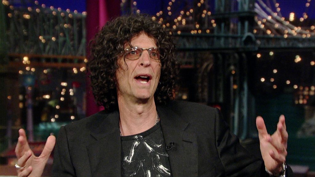Howard Stern animated with curly hair and glasses on Late Show with David Letterman set wallpaper background