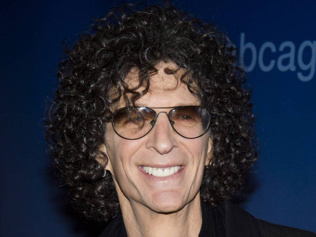 Howard Stern portrait with curly hair and tinted aviator glasses on dark blue background wallpaper