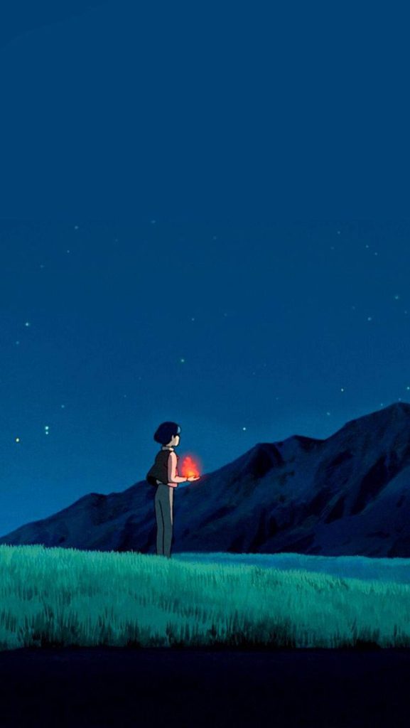 Howl holding glowing Calcifer in grassy field under starry night sky Studio Ghibli wallpaper