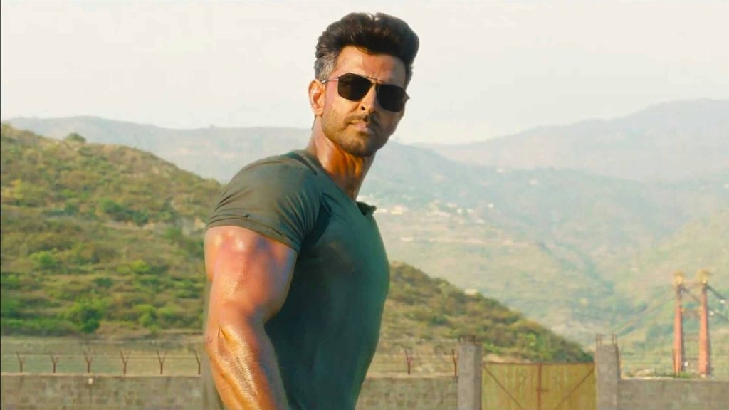 Hrithik Roshan rugged action pose olive green t shirt sunglasses mountain background wallpaper