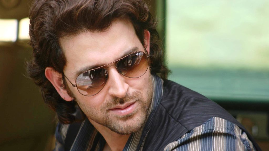 Hrithik Roshan close-up portrait with wavy hair aviator sunglasses rugged charm wallpaper background