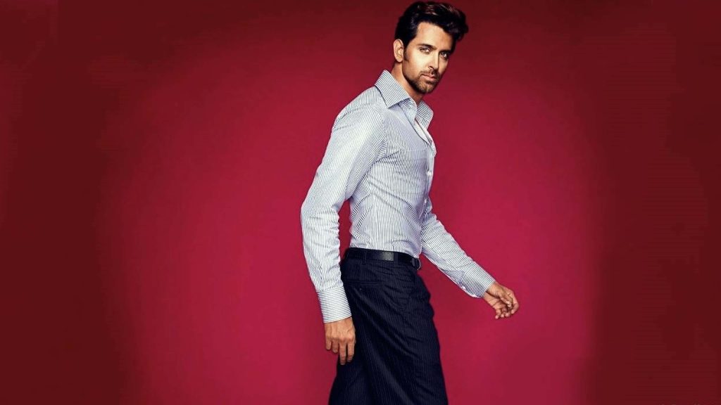 Hrithik Roshan in stylish striped shirt and trousers on vibrant magenta background wallpaper