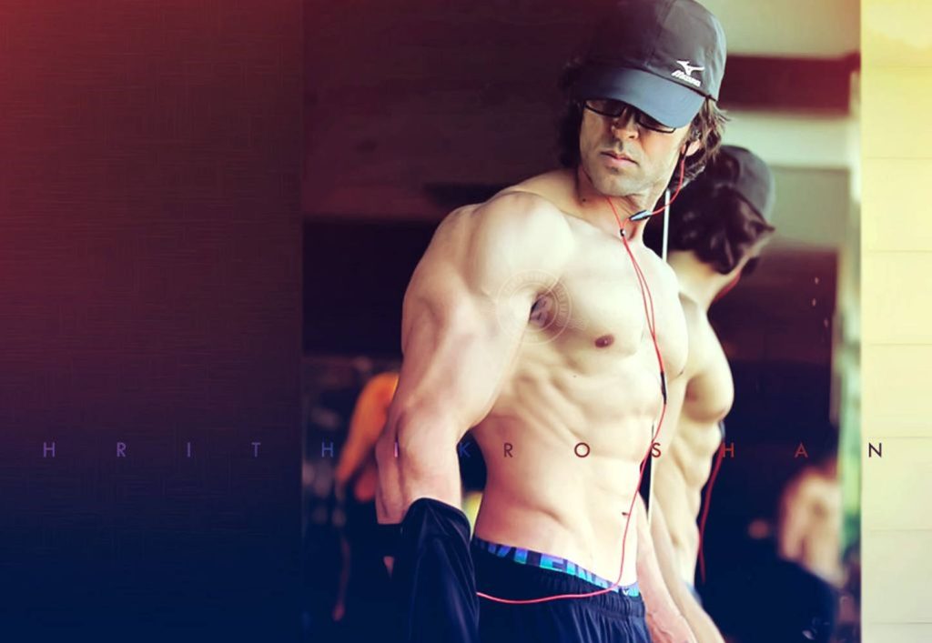Hrithik Roshan gym wallpaper showing chiseled physique black cap red earphones intense look