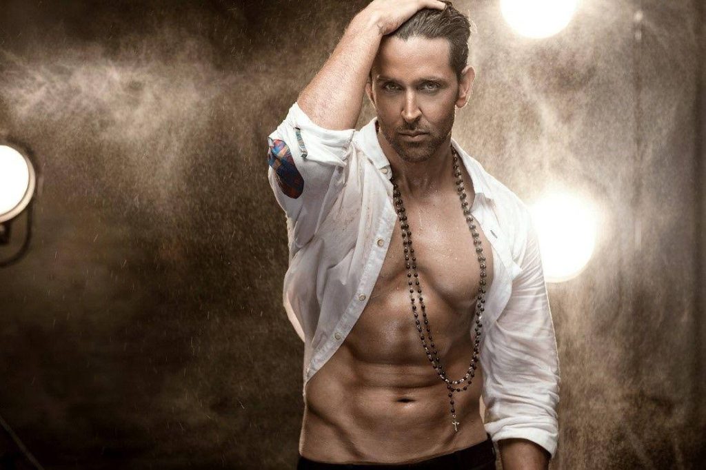 Hrithik Roshan moody cinematic wallpaper running hand through hair white shirt dusty studio background