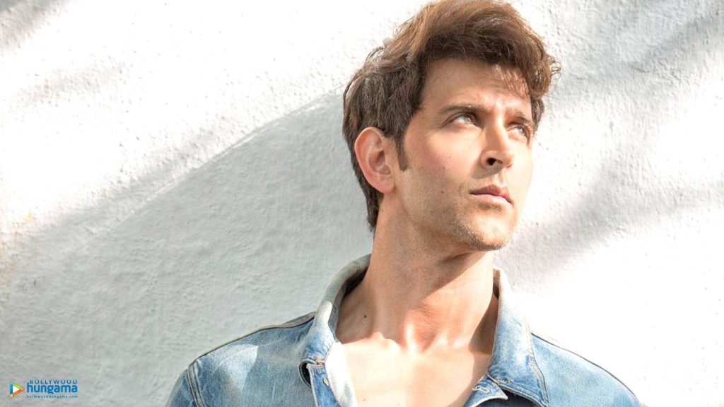 Hrithik Roshan portrait in stylish denim jacket natural light minimal white wall background wallpaper