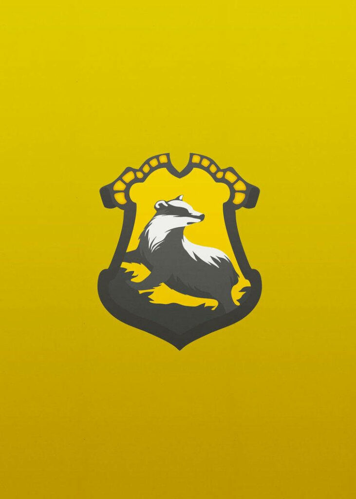 Hufflepuff Badger logo on bold yellow background representing loyalty and hard work wallpaper