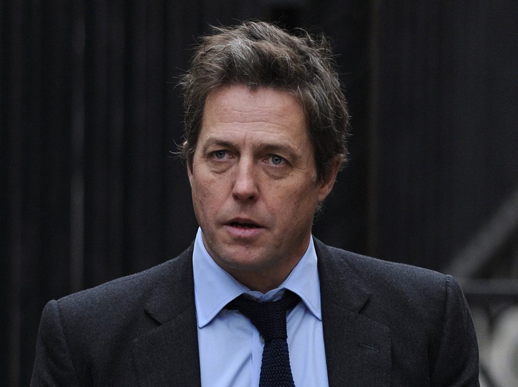 Hugh Grant portrait dark grey suit blue shirt intense expression natural light wallpaper
