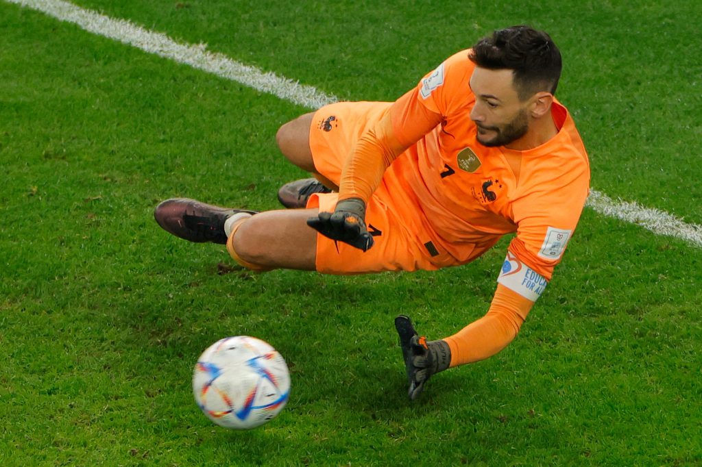 French goalkeeper Hugo Lloris diving in orange kit making a crucial 2022 World Cup save Wallpaper