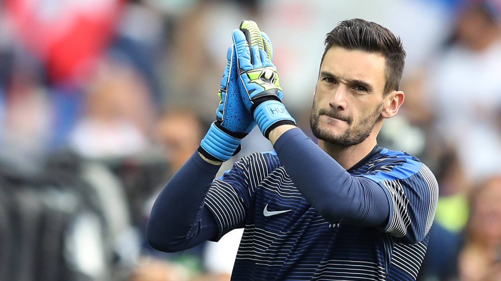 Hugo Lloris clapping in navy France jersey with gloves blurred stadium background wallpaper