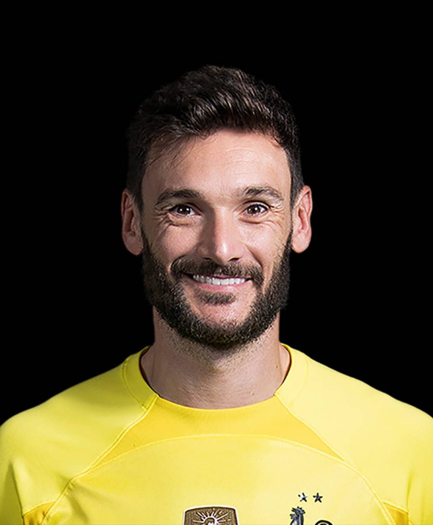Hugo Lloris in vibrant yellow French goalkeeper kit smiling in studio portrait on black background Wallpaper