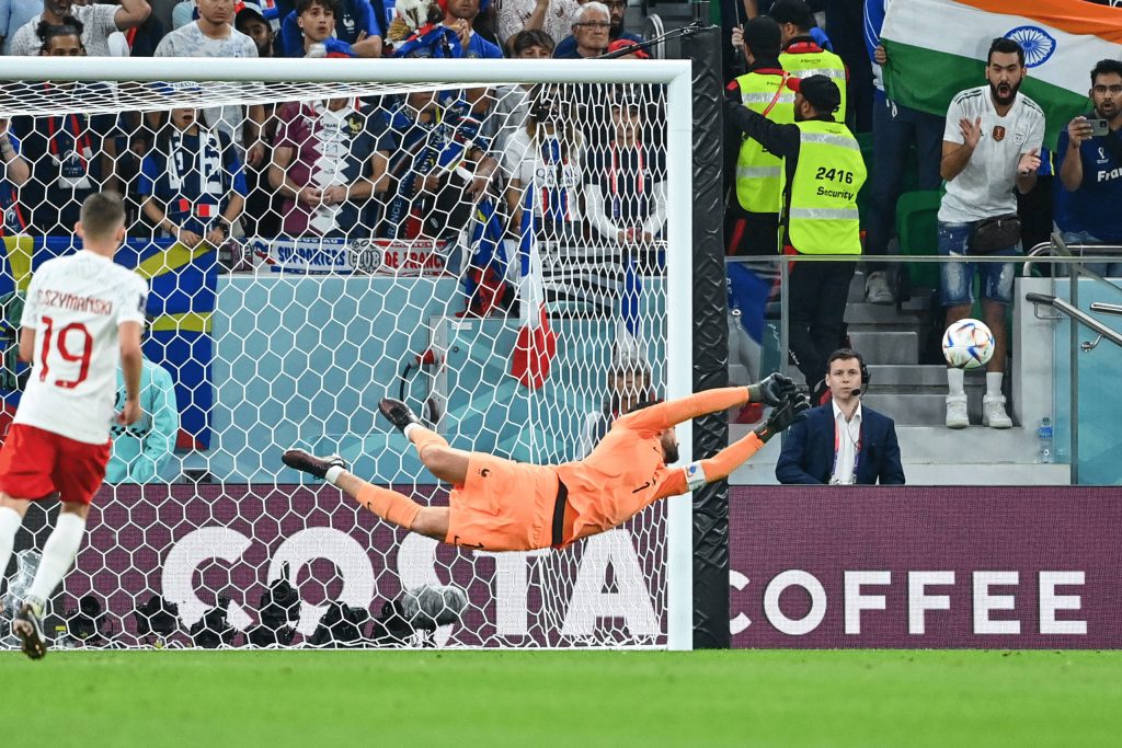 Hugo Lloris diving full stretch for a save with Sebastian Szymański in foreground FIFA World Cup Wallpaper
