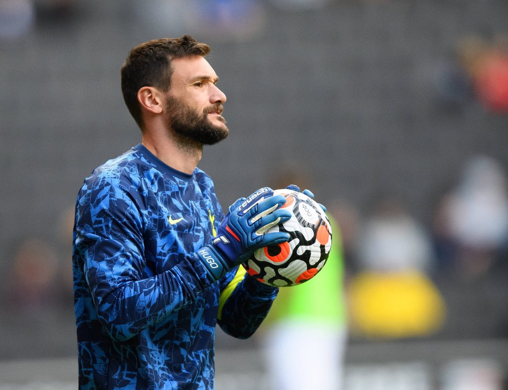 Hugo Lloris in blue training kit holding soccer ball with stadium background sports wallpaper