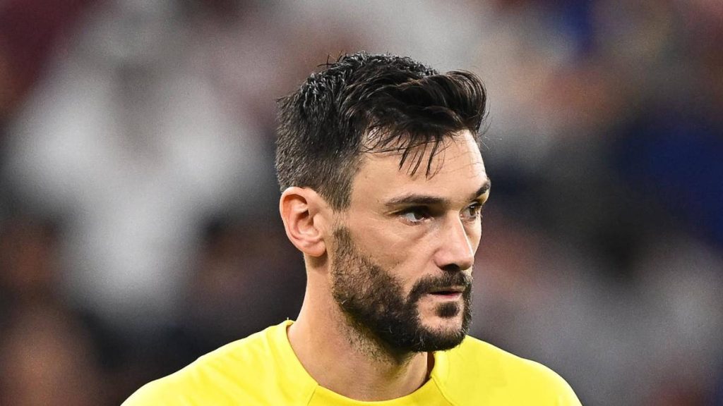 Hugo Lloris in bright yellow goalkeeper kit shows intense focus in blurred stadium background wallpaper