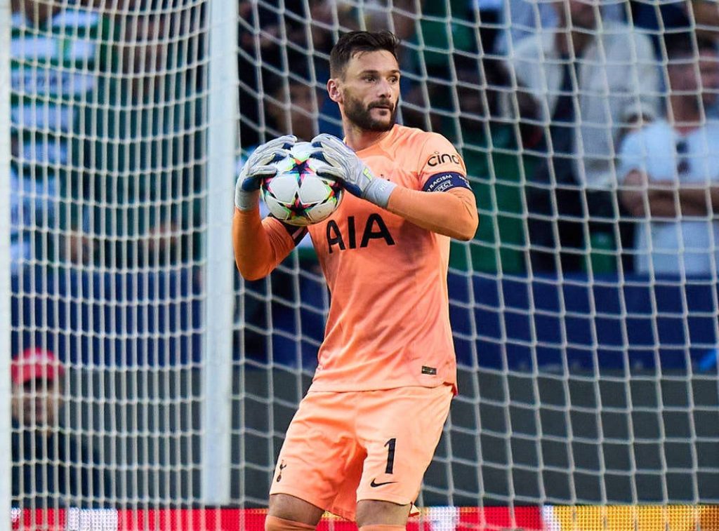 Hugo Lloris in orange kit clutching ball focused Tottenham Hotspur goalkeeper football wallpaper