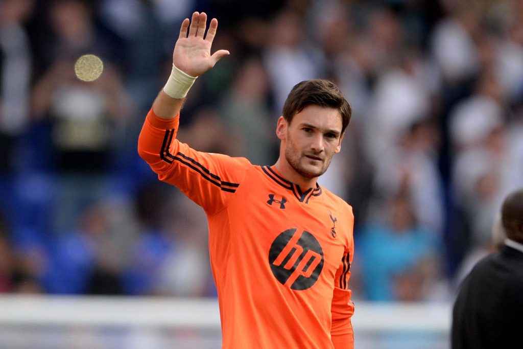 Hugo Lloris in orange Tottenham Hotspur jersey waving in stadium blurry background wallpaper