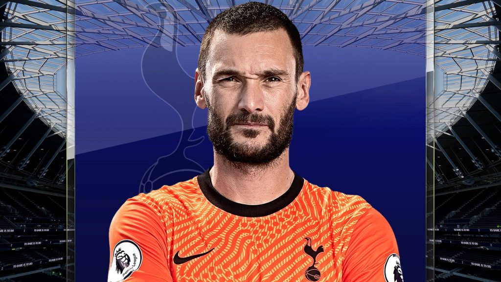 Hugo Lloris in orange kit on blue stadium background with Tottenham Hotspur motto wallpaper
