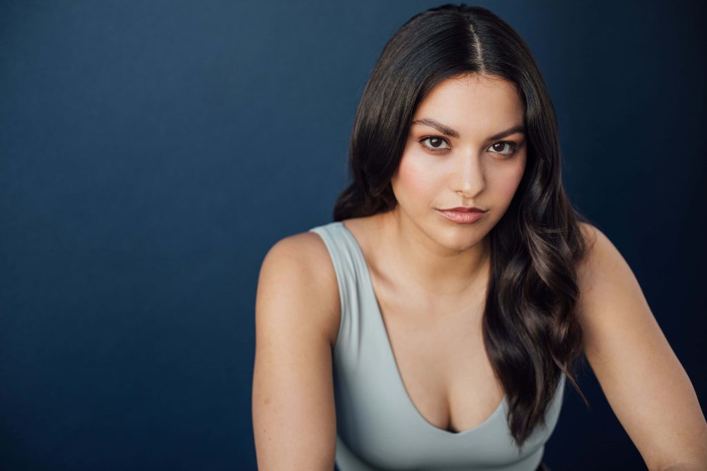 Professional portrait of actress Humberly González with dark wavy hair in grey tank top Wallpaper