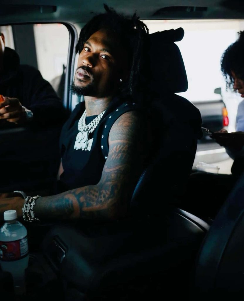 Hunxho candid portrait in car showing dreadlocks tattoos iced-out chains hip-hop wallpaper