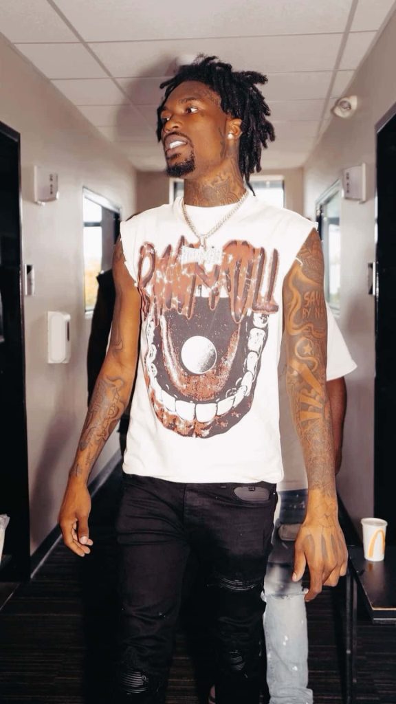 Hunxho rapper walking hallway dreadlocks tattoos white sleeveless shirt diamond chain wallpaper