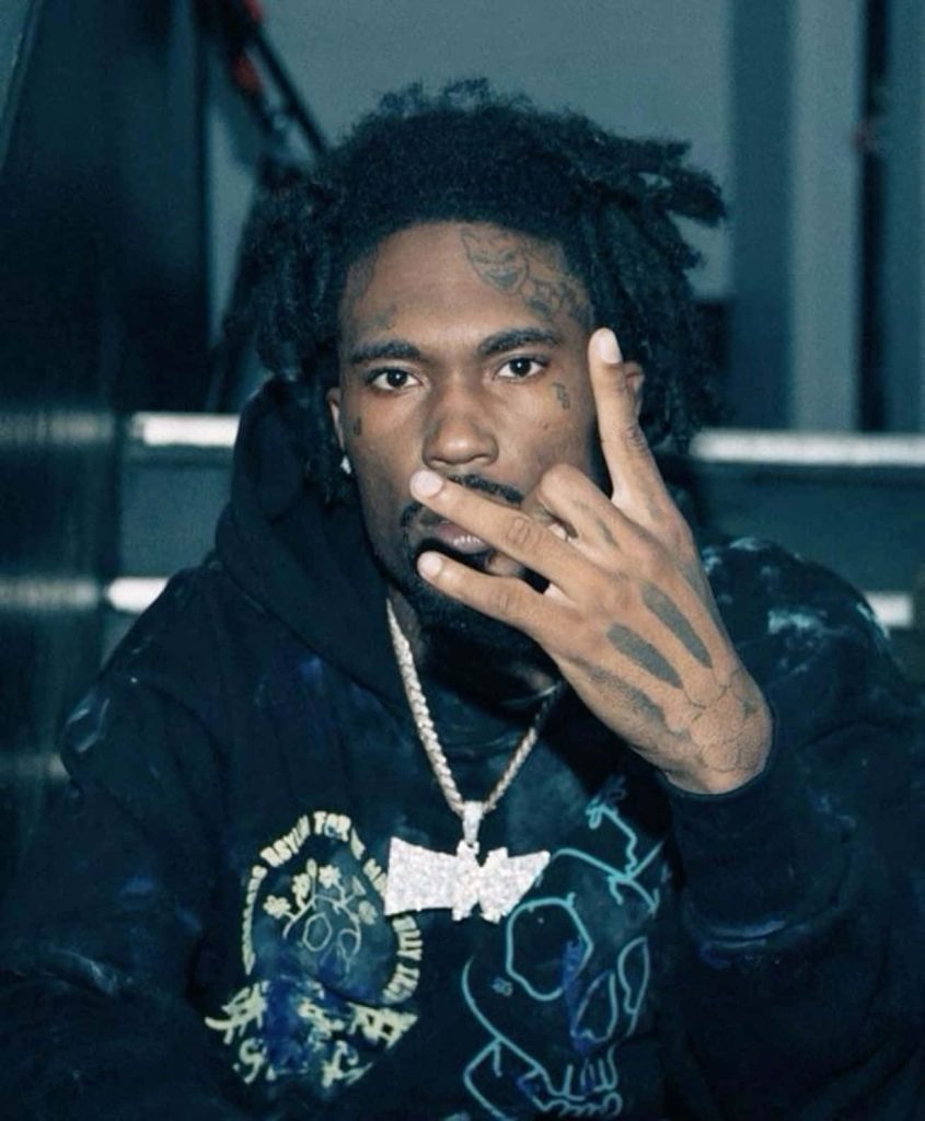 Rapper Hunxho in black graphic hoodie and iced chain with blue moody lighting wallpaper