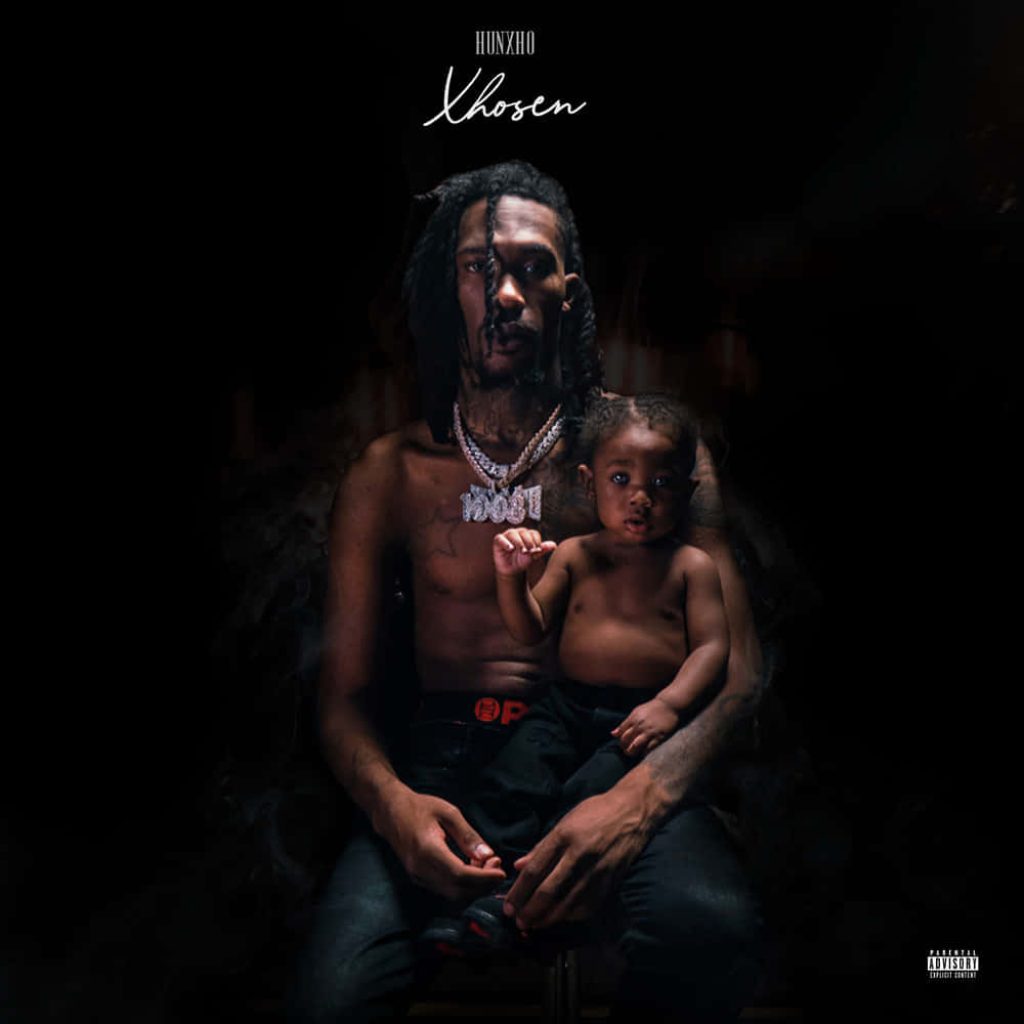 Hunxho shirtless wearing iced chains holding child dark moody album cover Xhosen professional portrait Wallpaper