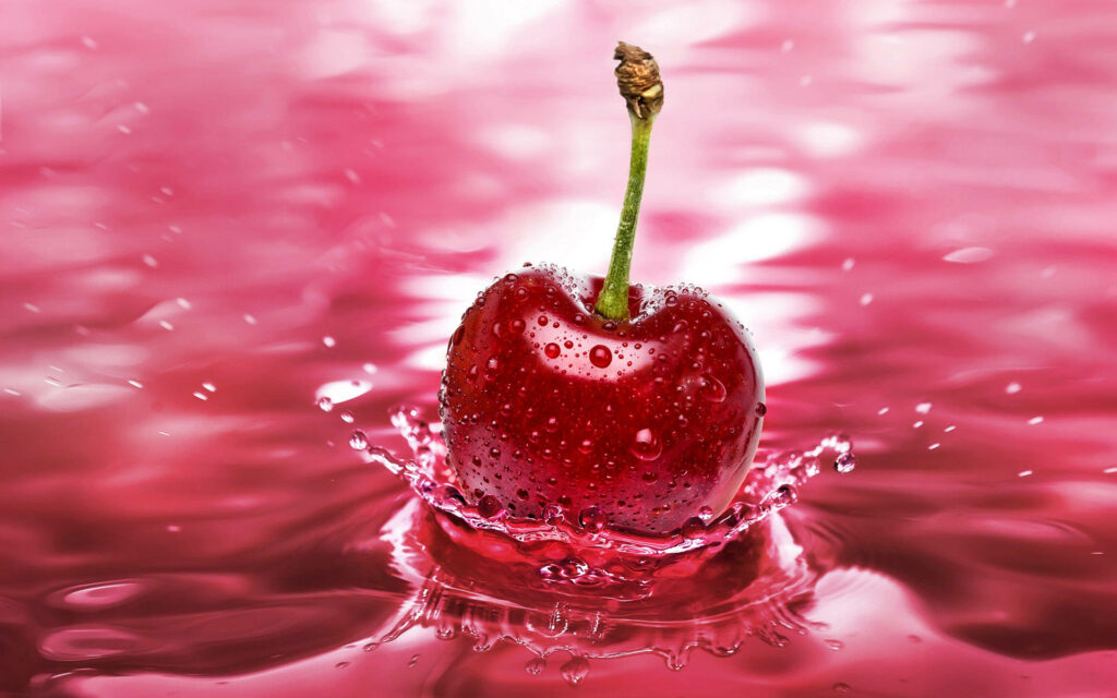 Glossy cherry splashing into vibrant pink water with ripples and glistening droplets background Wallpaper
