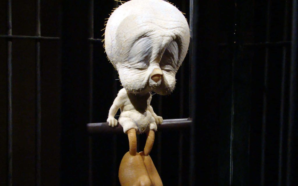 Hyper-realistic flesh-textured Tweety Bird sculpture in dark cage eerie surreal wallpaper background