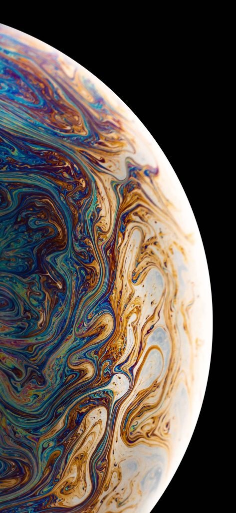 Macro soap film with iridescent gold blue cream swirls on black perfect for iPhone wallpaper