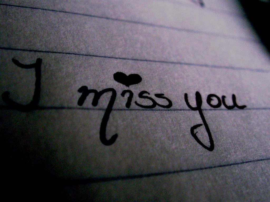 Moody close-up of handwritten I miss you with heart dot on lined notebook paper wallpaper