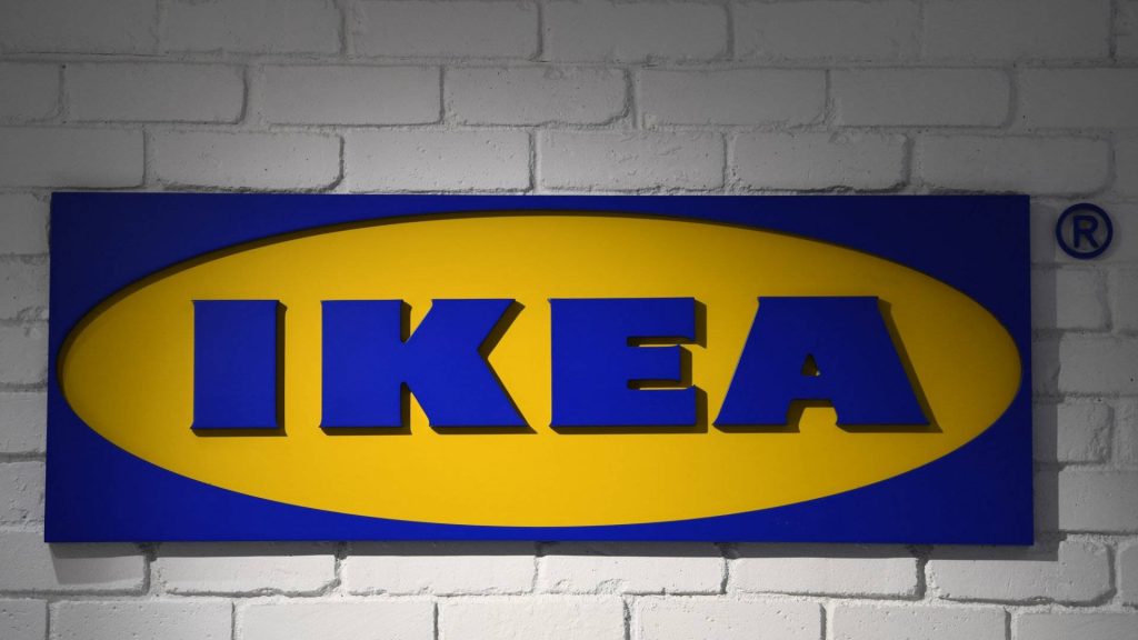 IKEA logo wallpaper on rustic white brick wall with modern industrial retail design lighting
