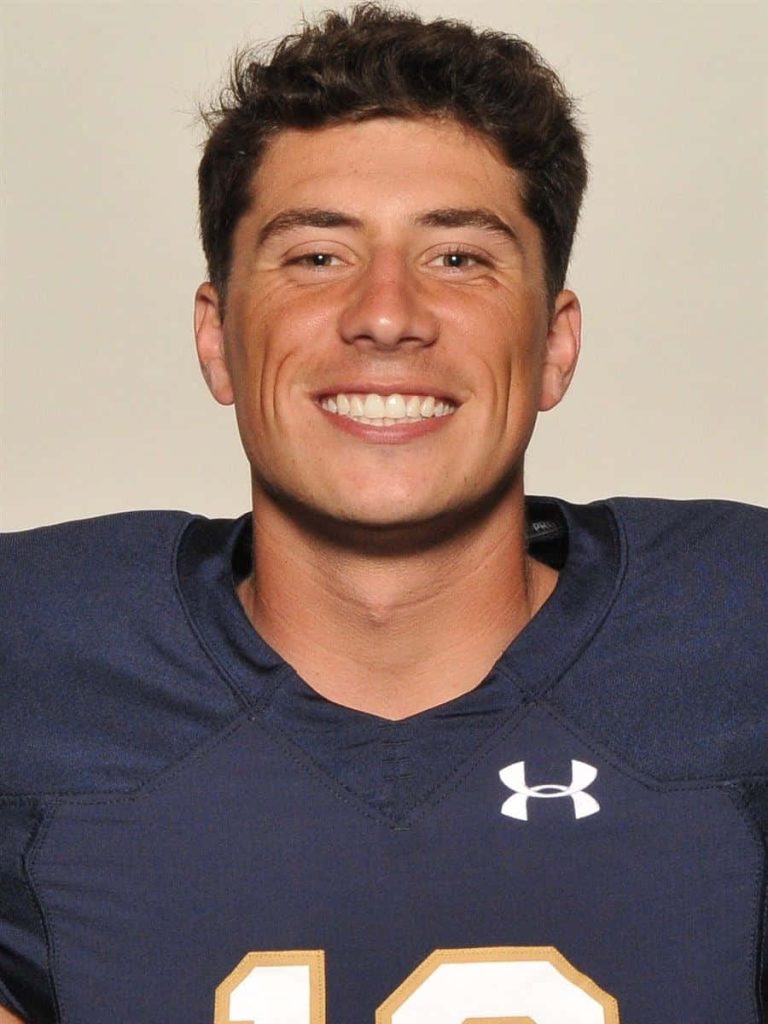 Ian Book smiling headshot in navy Under Armour jersey studio portrait wallpaper background