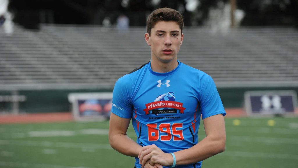 Young NFL quarterback Ian Book in blue Under Armour gear at Rivals Camp football field wallpaper