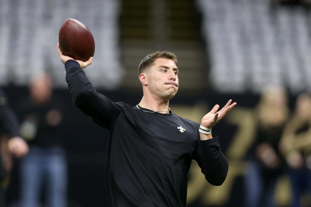 New Orleans Saints quarterback Ian Book mid-throw in black training shirt indoor practice Wallpaper