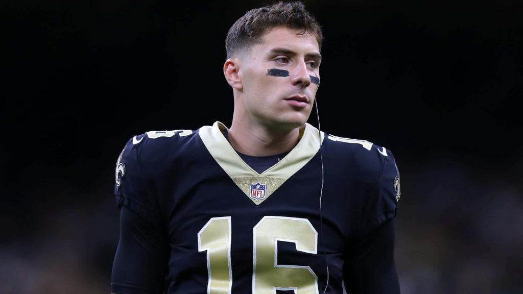 Ian Book focused New Orleans Saints quarterback in black jersey number 16 sports wallpaper background