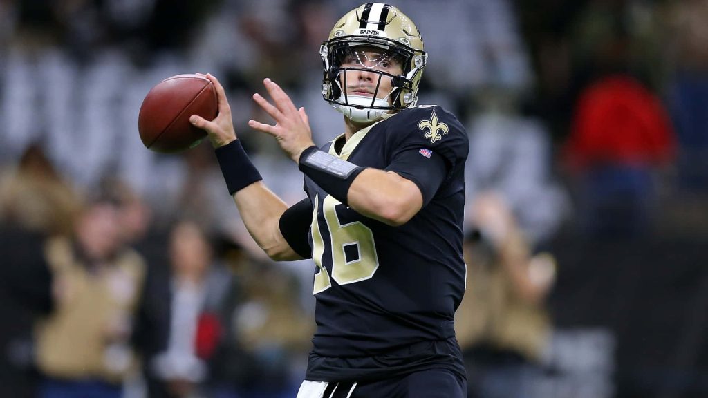 Ian Book New Orleans Saints quarterback mid-throw in black jersey NFL action wallpaper background