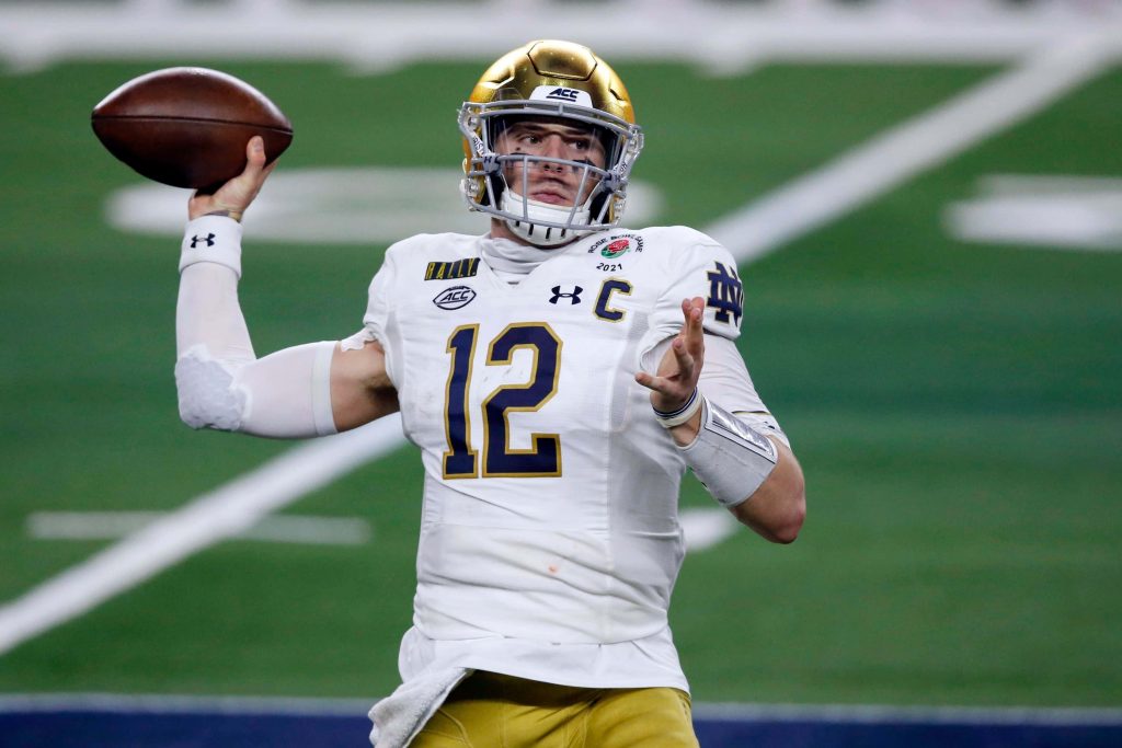 Notre Dame quarterback Ian Book throwing pass in white jersey Rose Bowl 2021 action shot Wallpaper