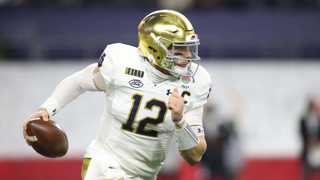 Ian Book Notre Dame quarterback scrambling in 2021 Rose Bowl gold helmet white jersey wallpaper