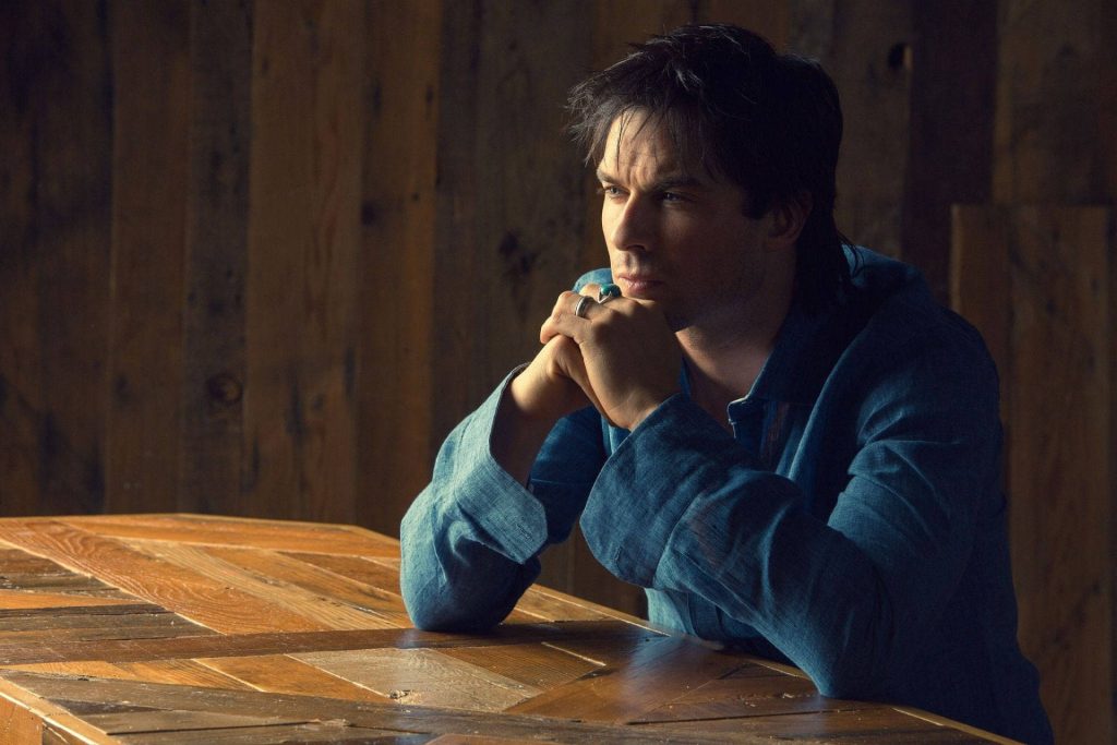 Ian Somerhalder calm contemplative portrait blue shirt rustic wooden table cinematic lighting Wallpaper