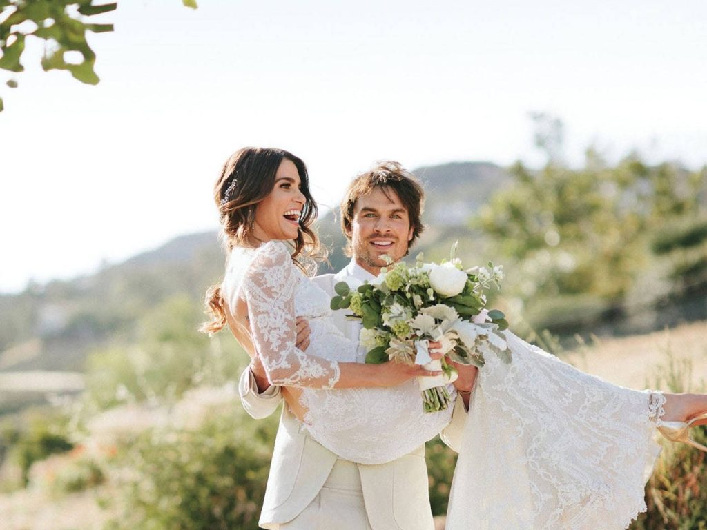 Ian Somerhalder carrying bride Nikki Reed in white lace gown outdoors romantic wedding wallpaper background