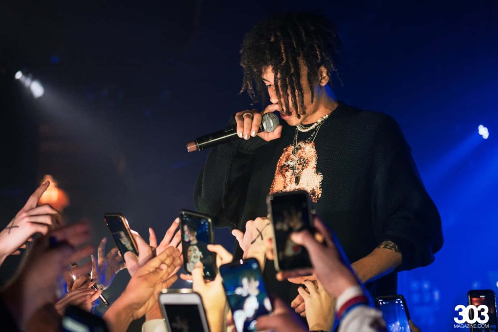 Iann Dior live concert wallpaper with moody lighting and fans capturing the performance on phones