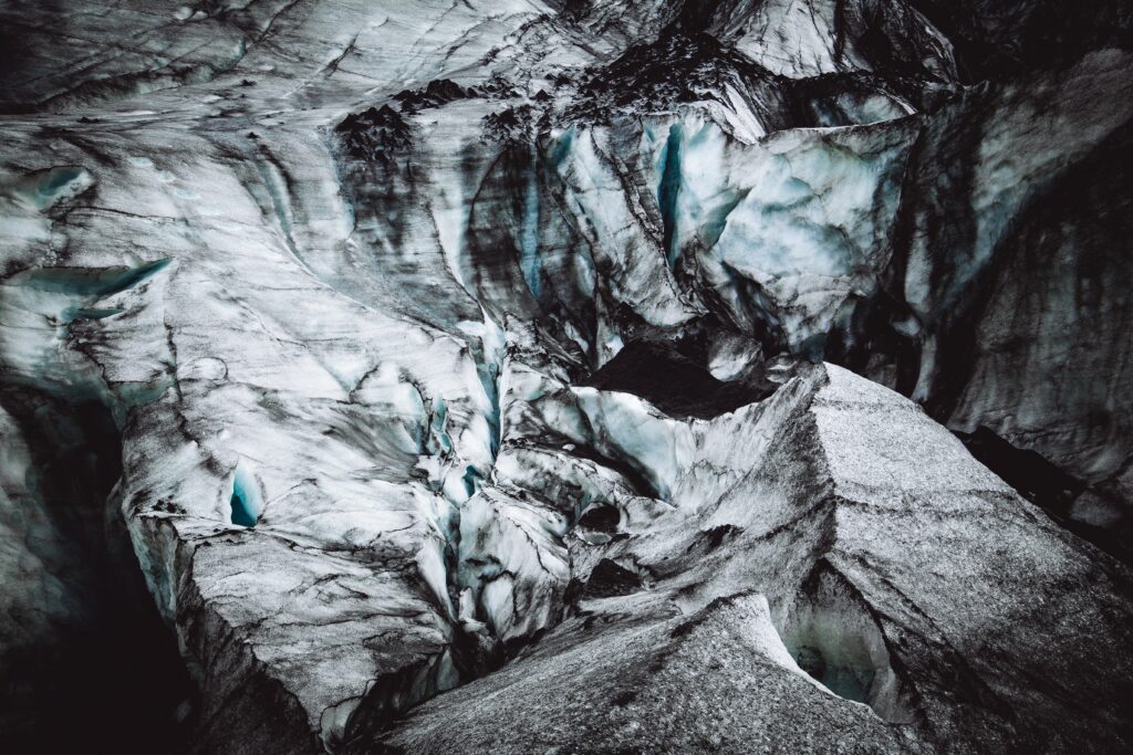 Glacier cave surface in Iceland with swirling ice patterns and deep blue natural textures wallpaper