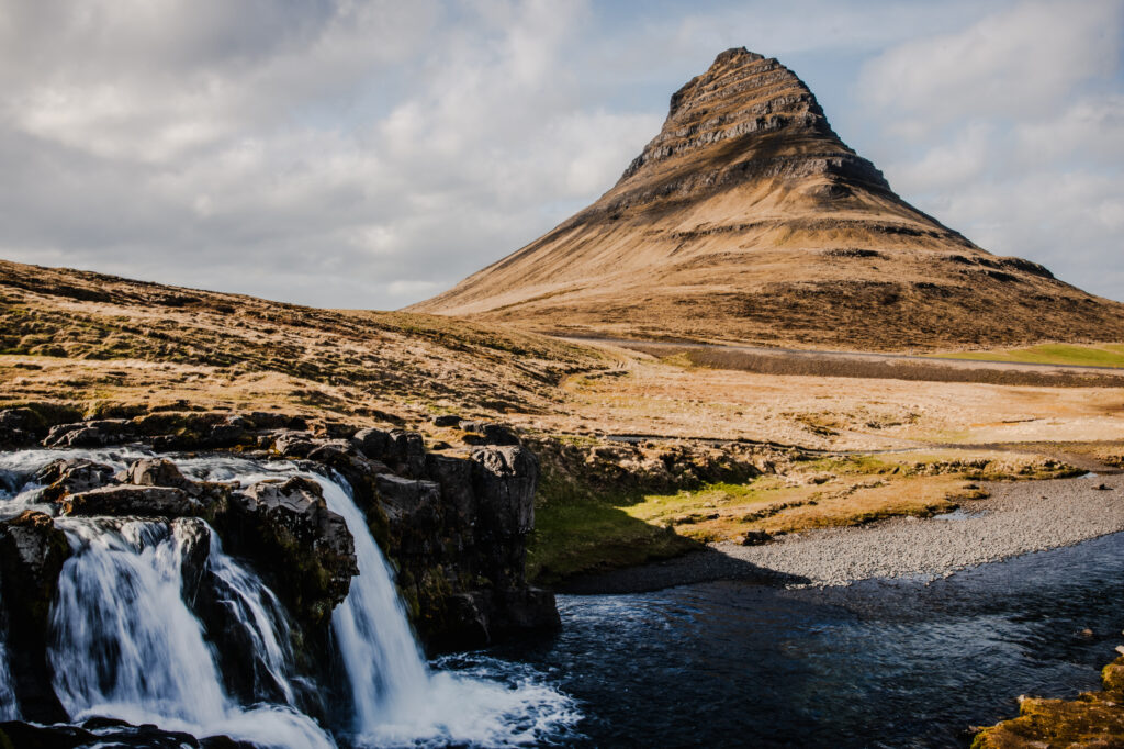 Iceland landscape with rugged mountain waterfall valley natural light earthy tones wallpaper background