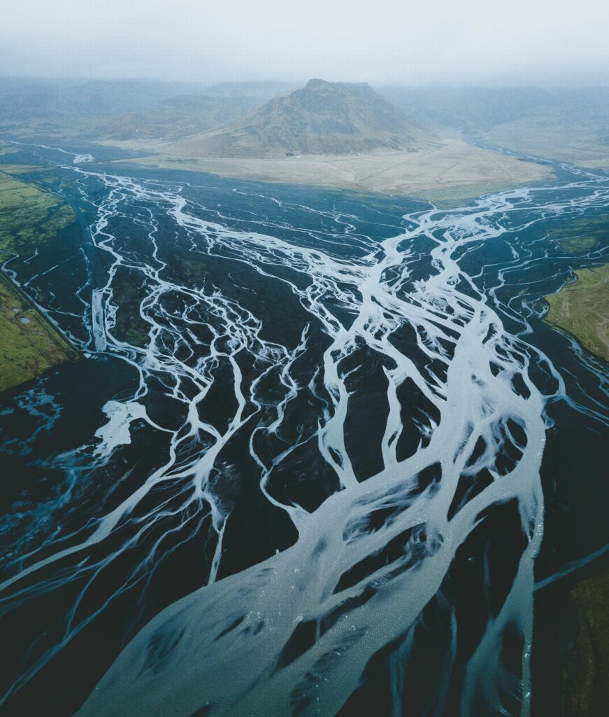 Iceland volcanic landscape wallpaper braided rivers dark terrain misty mountains blue tones