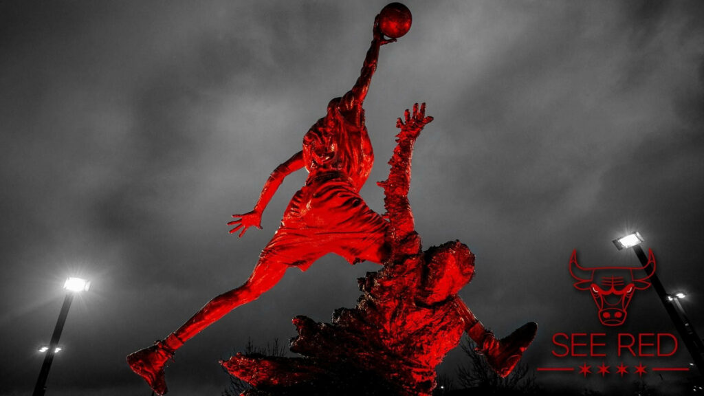 Iconic Michael Jordan Statue Soars with Intense Red Hues in Bulls' Arena Wallpaper