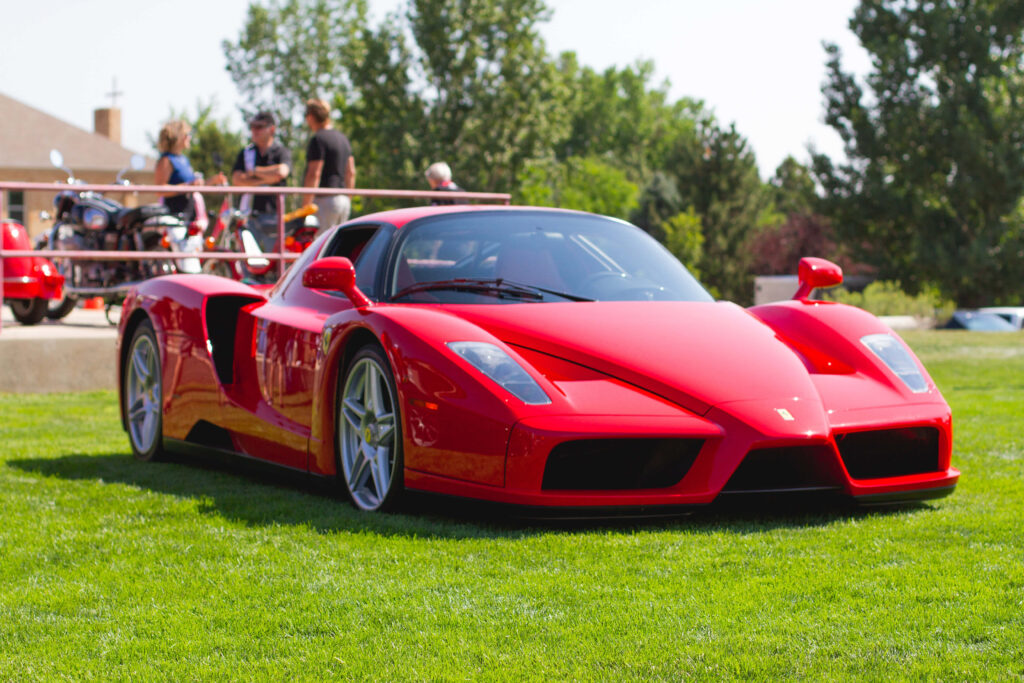 Ferrari's Majestic Arrival: A Snapshot of Automotive Excellence against Maranello's Gateway Wallpaper