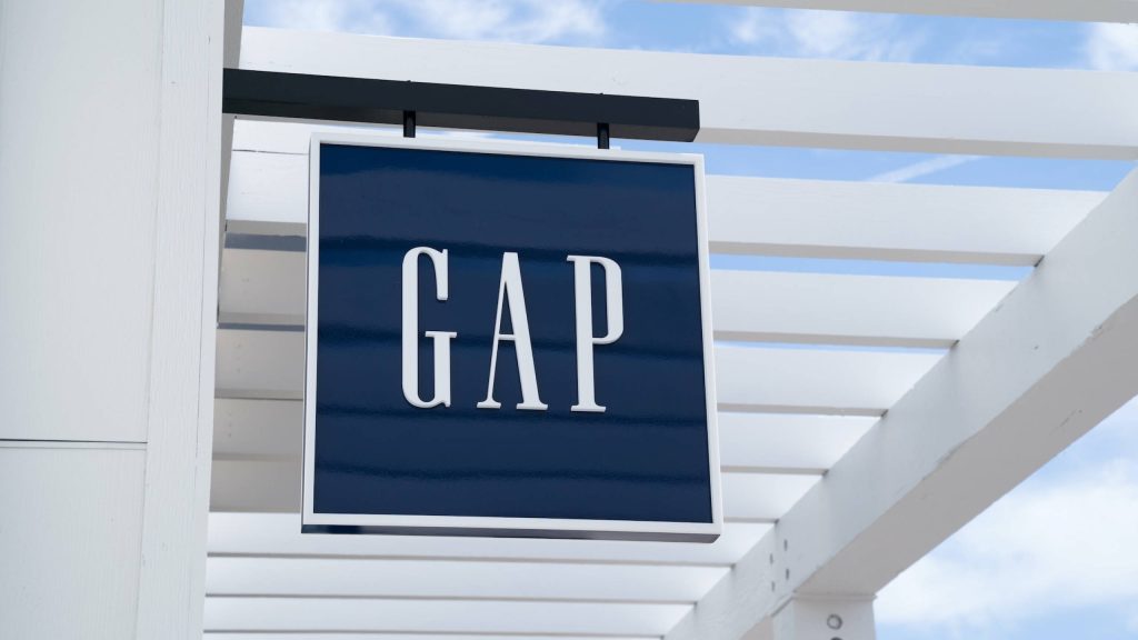 Gap store sign navy blue white serif letters pergola bright clear sky retail style background Wallpaper
