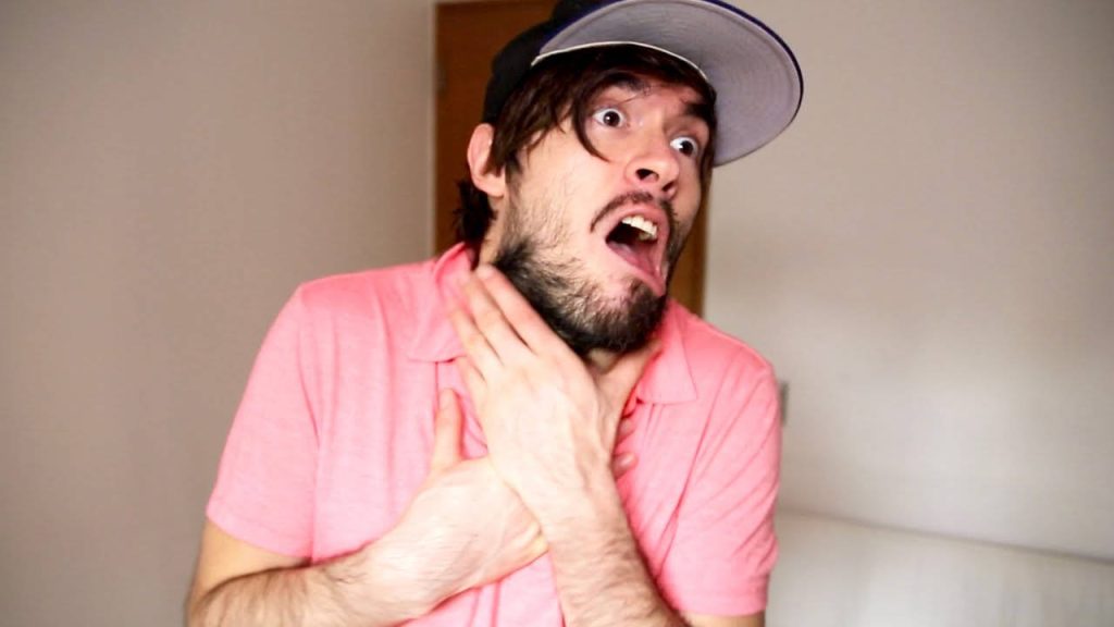 Bright wallpaper of YouTuber Germán Garmendia in pink shirt and cap comically choking himself