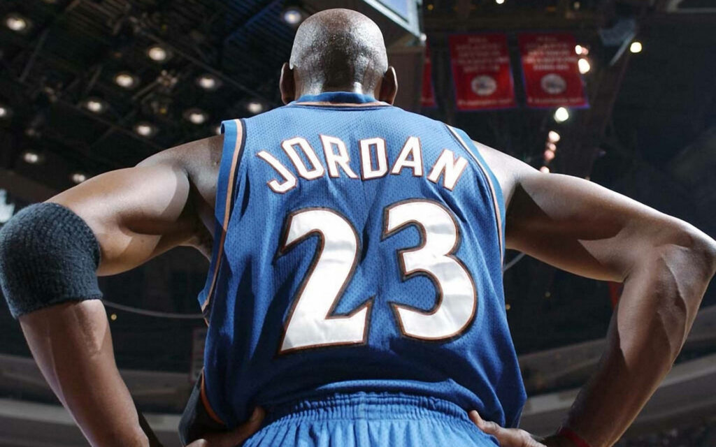 The Legend Returns: Michael Jordan Strikes Back in Washington Wizards Jersey - Towering Triumph Captured in Breathtaking Low-Angle Photography! Wallpaper
